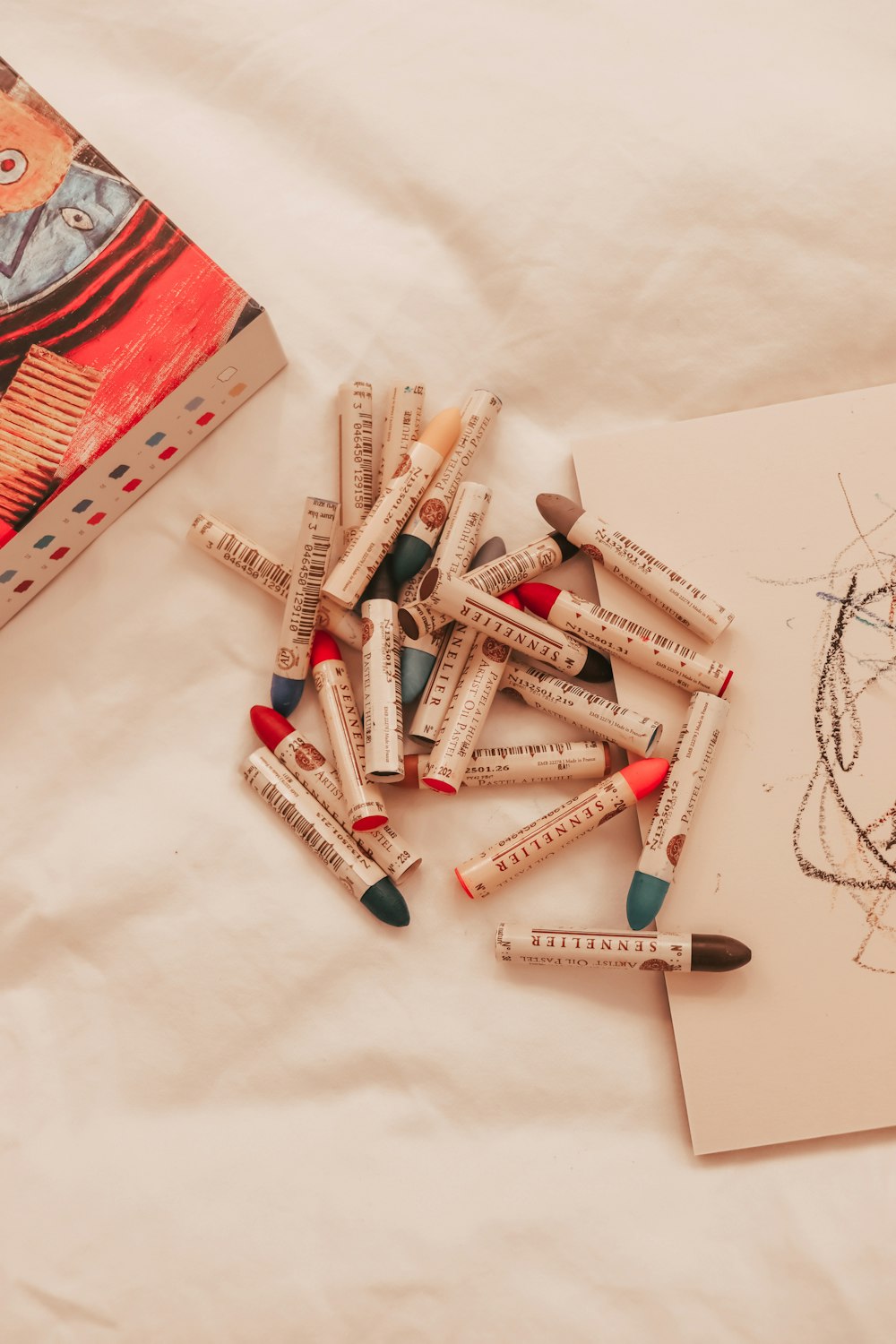 a pile of crayons sitting on top of a table next to a book