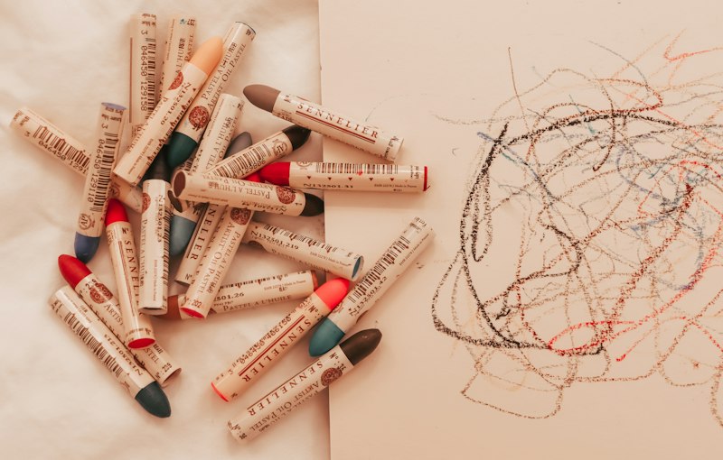 Crayons resting on a child's drawing