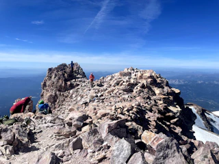 A vibrant scene of hikers and cyclists enjoying a sunny day in the mountains, showcasing outdoor adventure gear.
