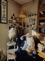 A cozy corner with a vintage picture frame and a soft knit throw pillow beside a window.