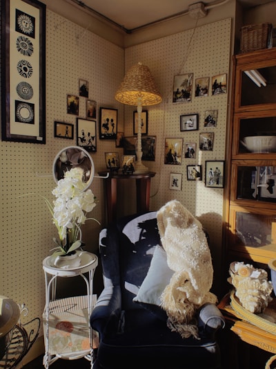 A cozy corner featuring a black and red floral crochet throw pillow on a vintage armchair.