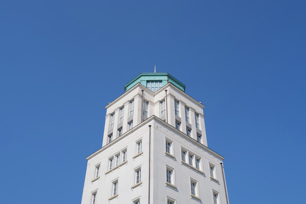 a tall white building with a green top