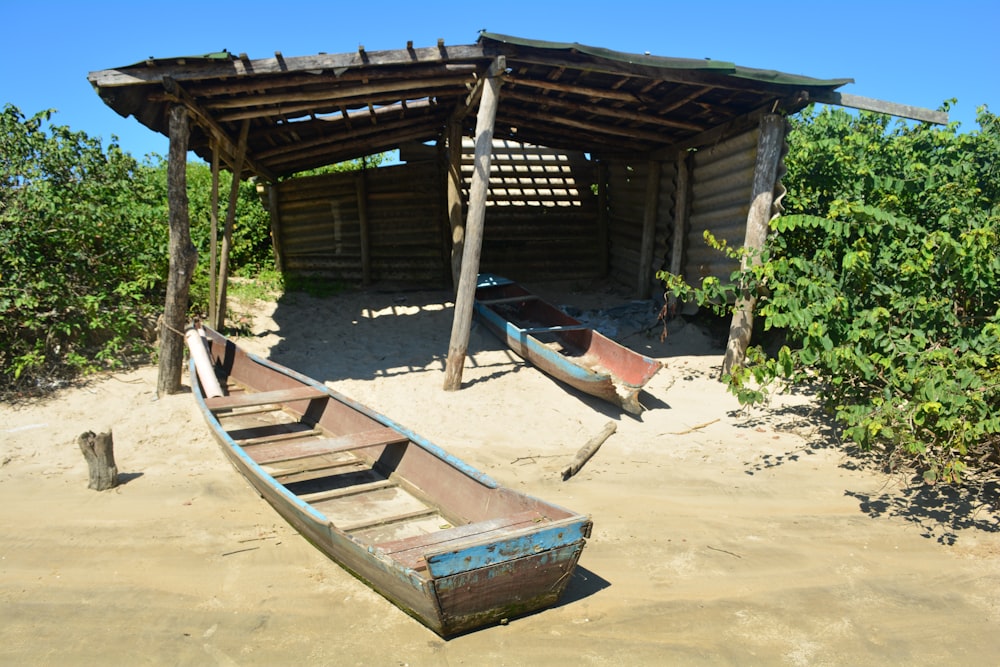 a wooden boat sitting on top of a sandy beach