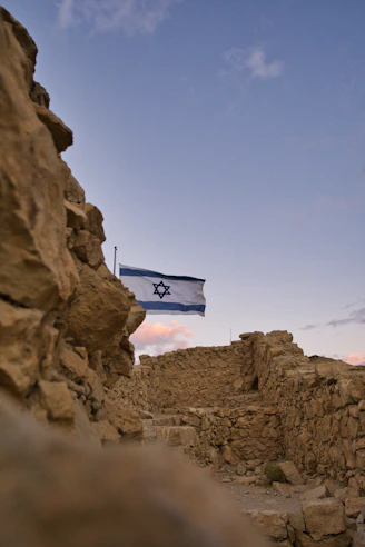 an israeli flag flying over a rocky area