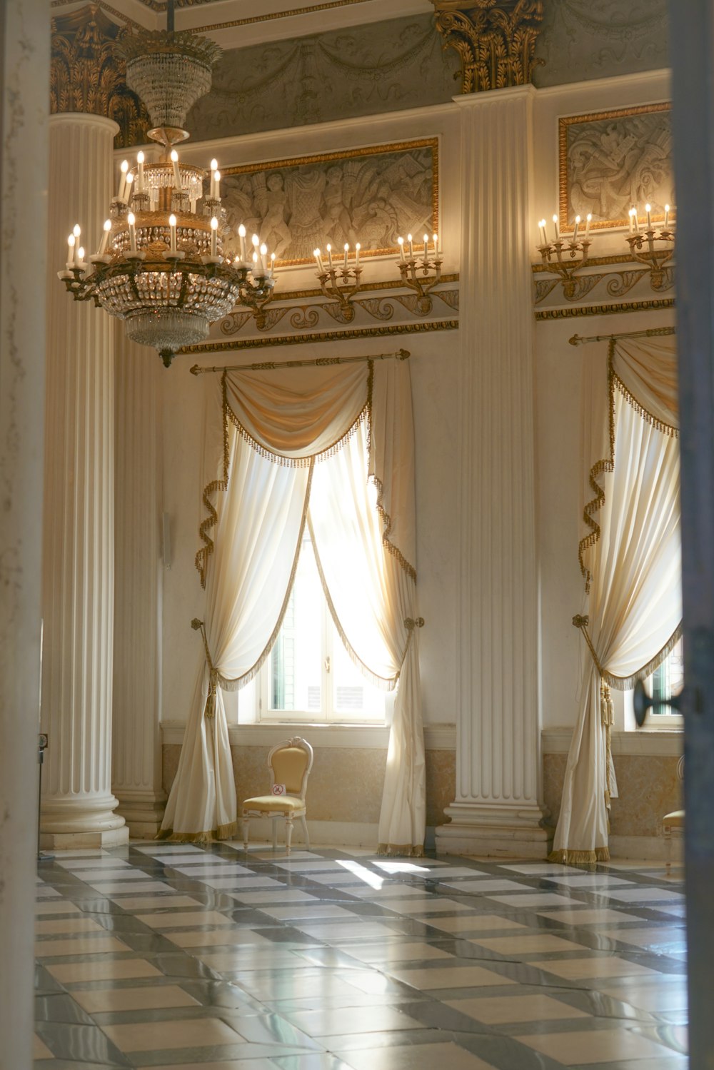 a room with a chandelier and a chair in it