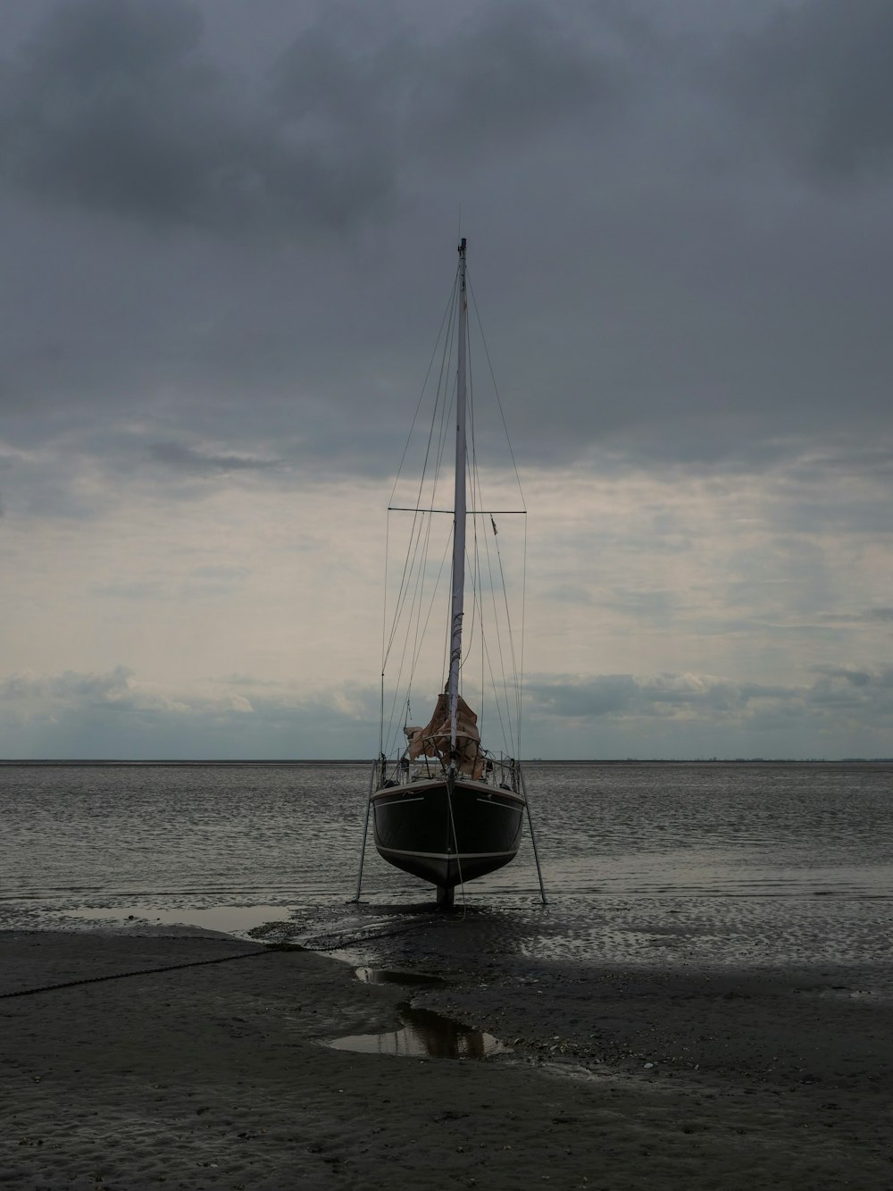 a sailboat sitting in the water on a beach