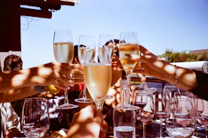 Guests enjoying a sunny outdoor champagne reception with live music playing softly