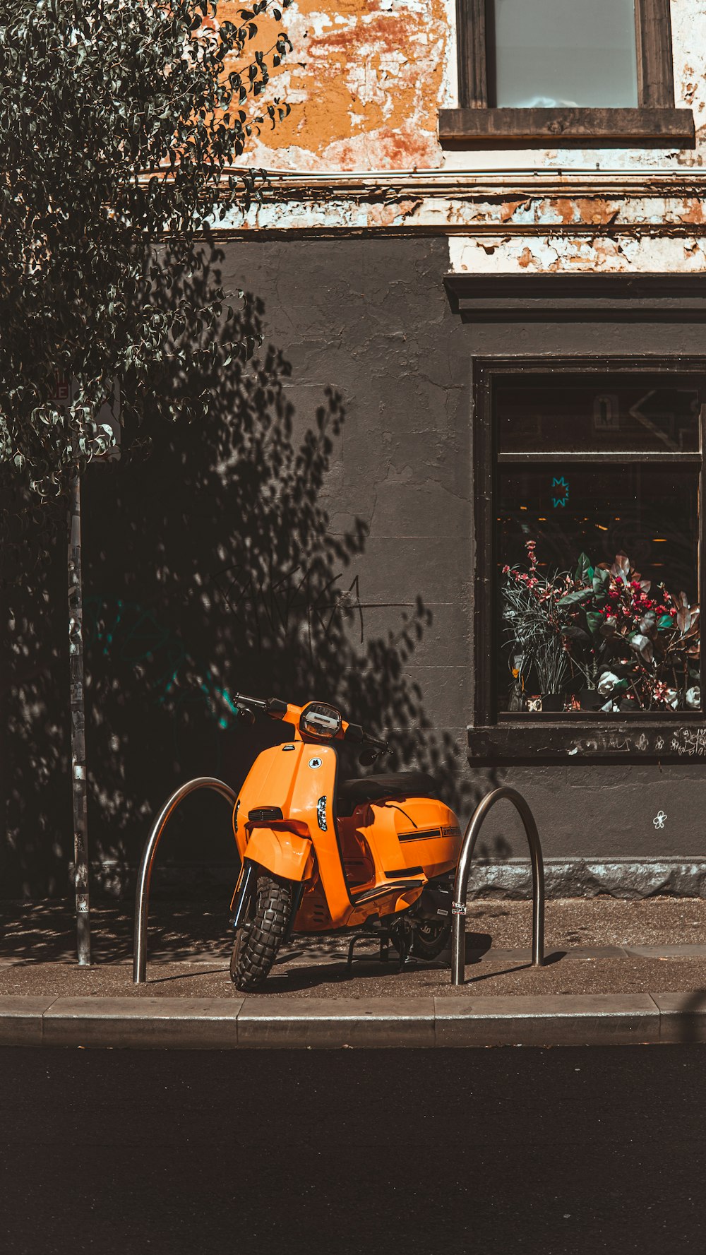 an orange scooter parked in front of a building