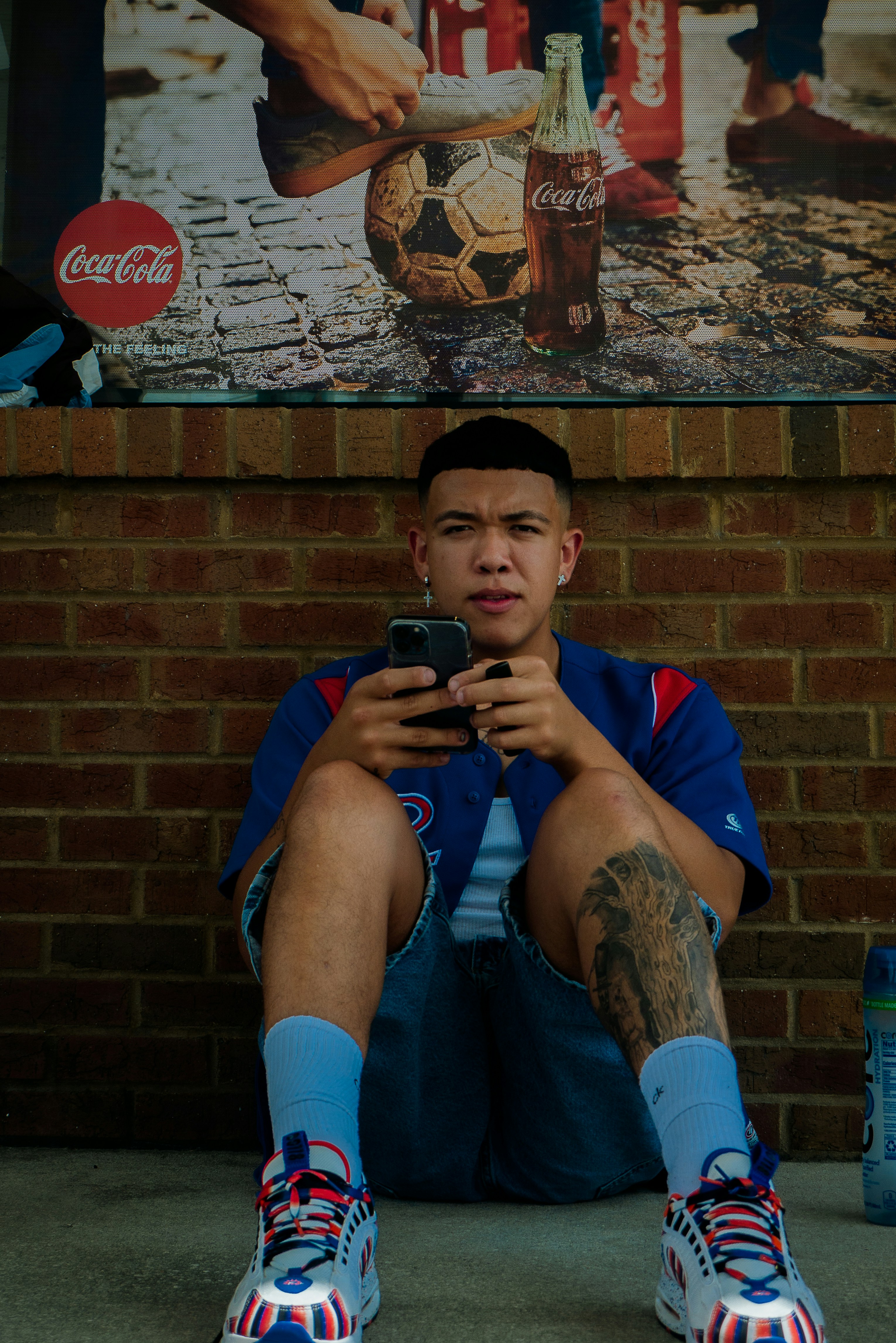 a man sitting on the ground holding a cell phone