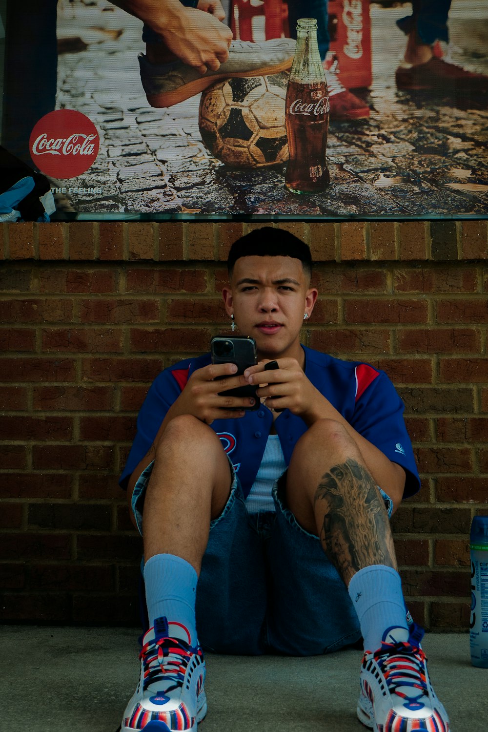 a man sitting on the ground holding a cell phone