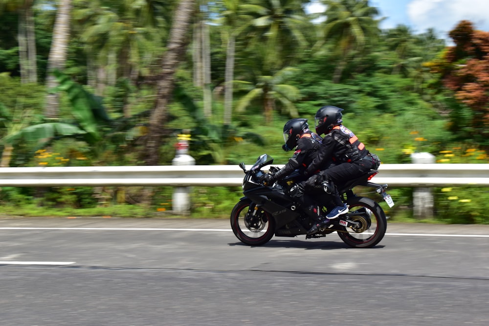 two people riding a motorcycle on a road