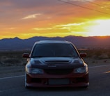 A sleek Sierra model parked on a scenic mountain road at sunset.