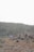 A small group biking along a rugged trail with desert mountains in the background.