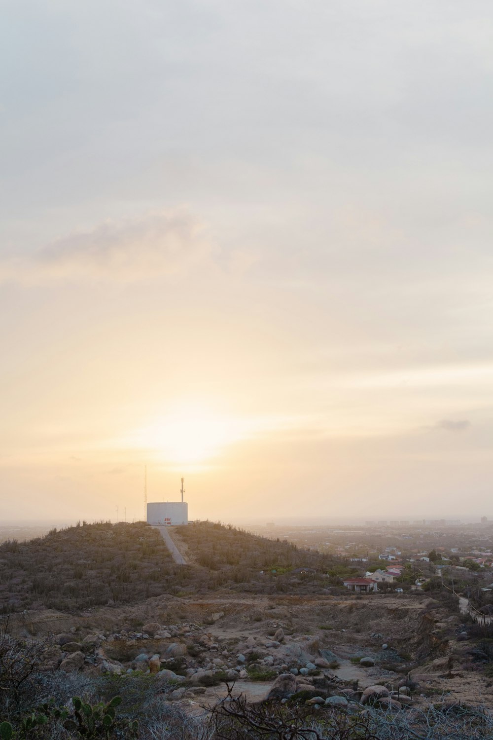 the sun is setting over a rocky hill