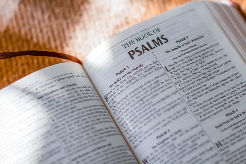 an open bible with a brown ribbon on top of it