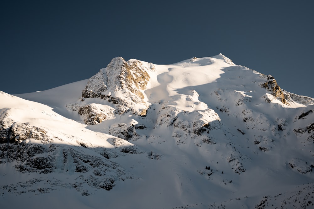 a mountain covered in snow under a blue sky