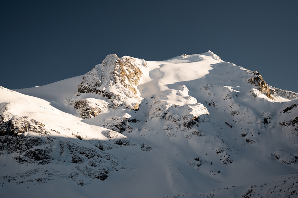 Ein schneebedeckter Berg unter blauem Himmel