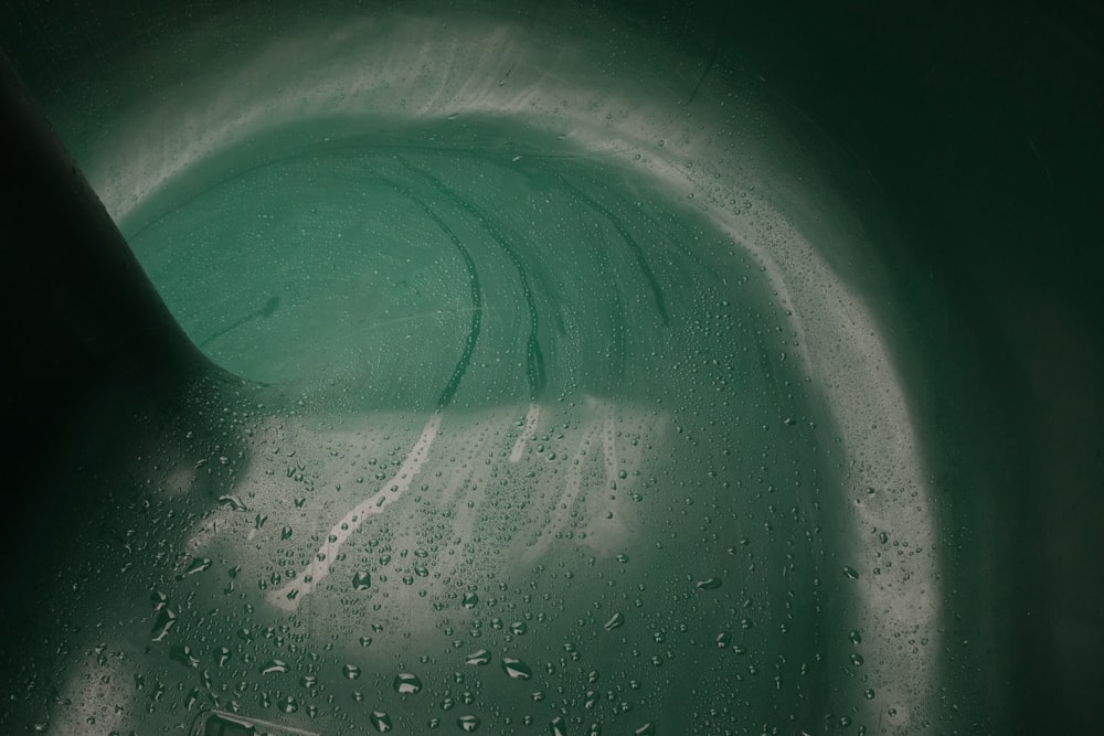 a close up of a green bowl with water