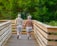 A joyful senior couple walking hand in hand through a sunlit forest trail.