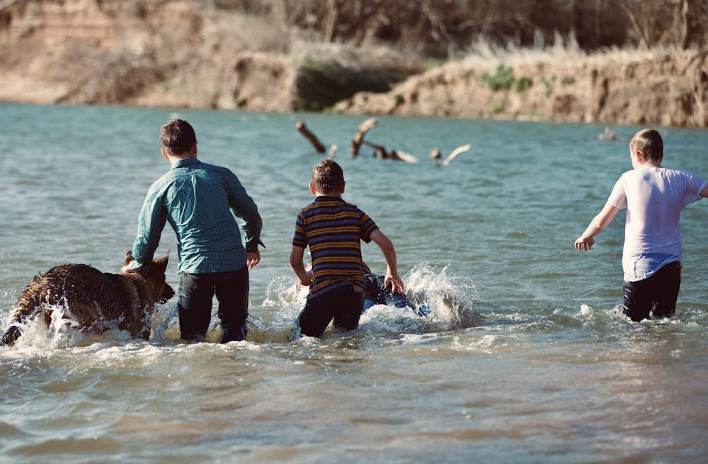 a group of people wading in the water with a dog