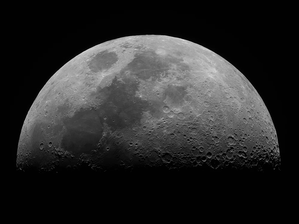 Cratered lunar surface illuminated against black space