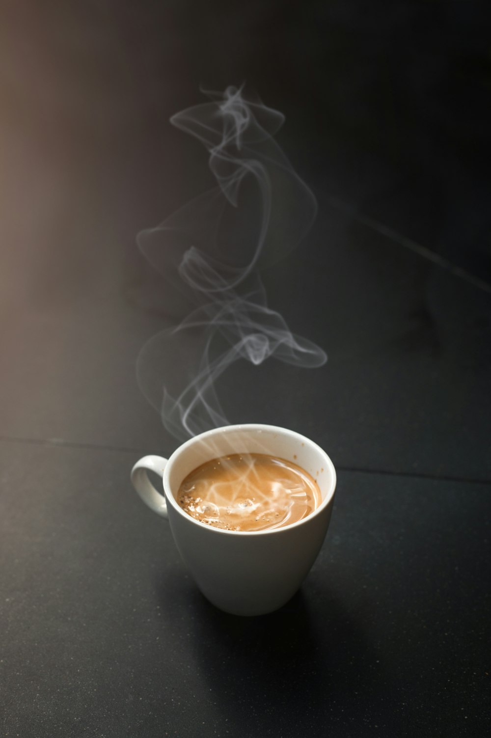 a cup of coffee with steam coming out of it