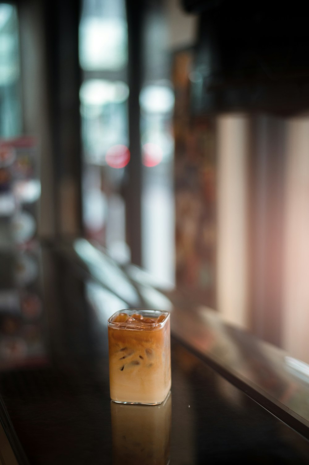 a drink sitting on top of a table next to a window