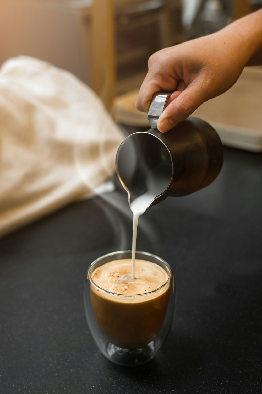 a person pours coffee into a cup