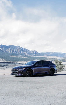 Drone shot capturing an exotic car parked in a scenic mountain pass.