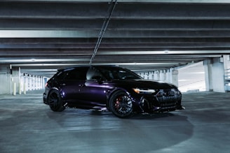 Elegant black car with a matte covering film in a stylish garage.