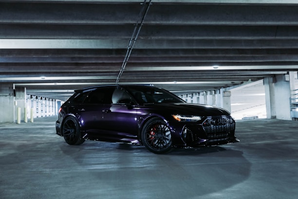 Close-up of a sleek black car secured inside a modern transport vehicle.