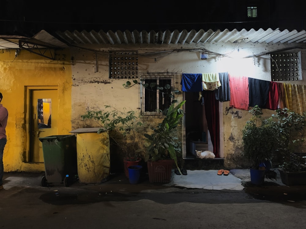 a man standing in front of a yellow building