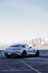 Sleek light vehicle parked in an industrial lot with a clear sky background