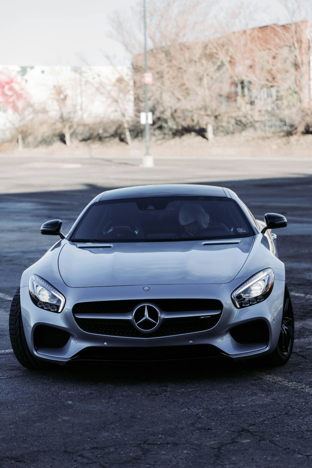 Une Mercedes sport argentée garée dans un parking