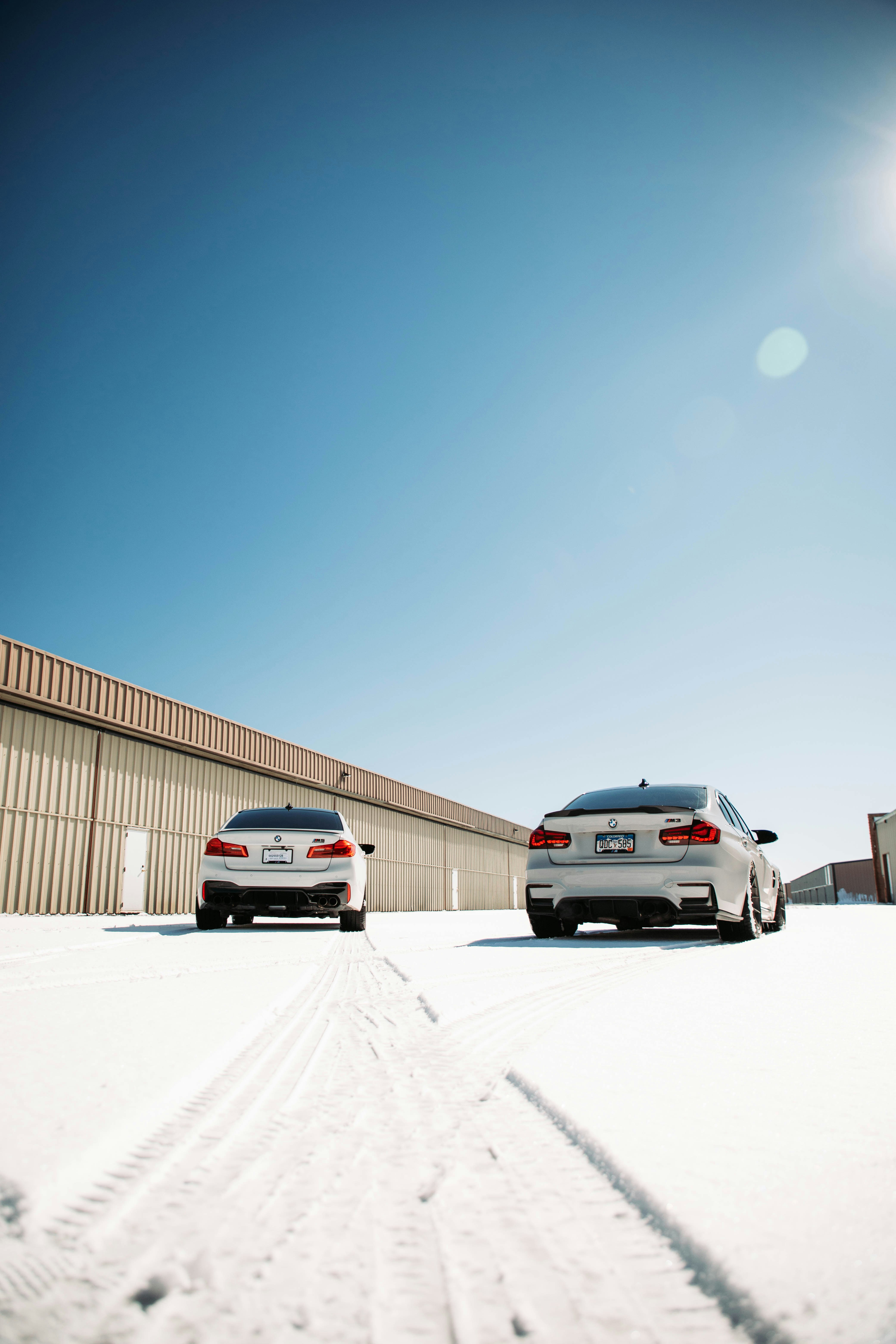 two cars parked in the snow near a building