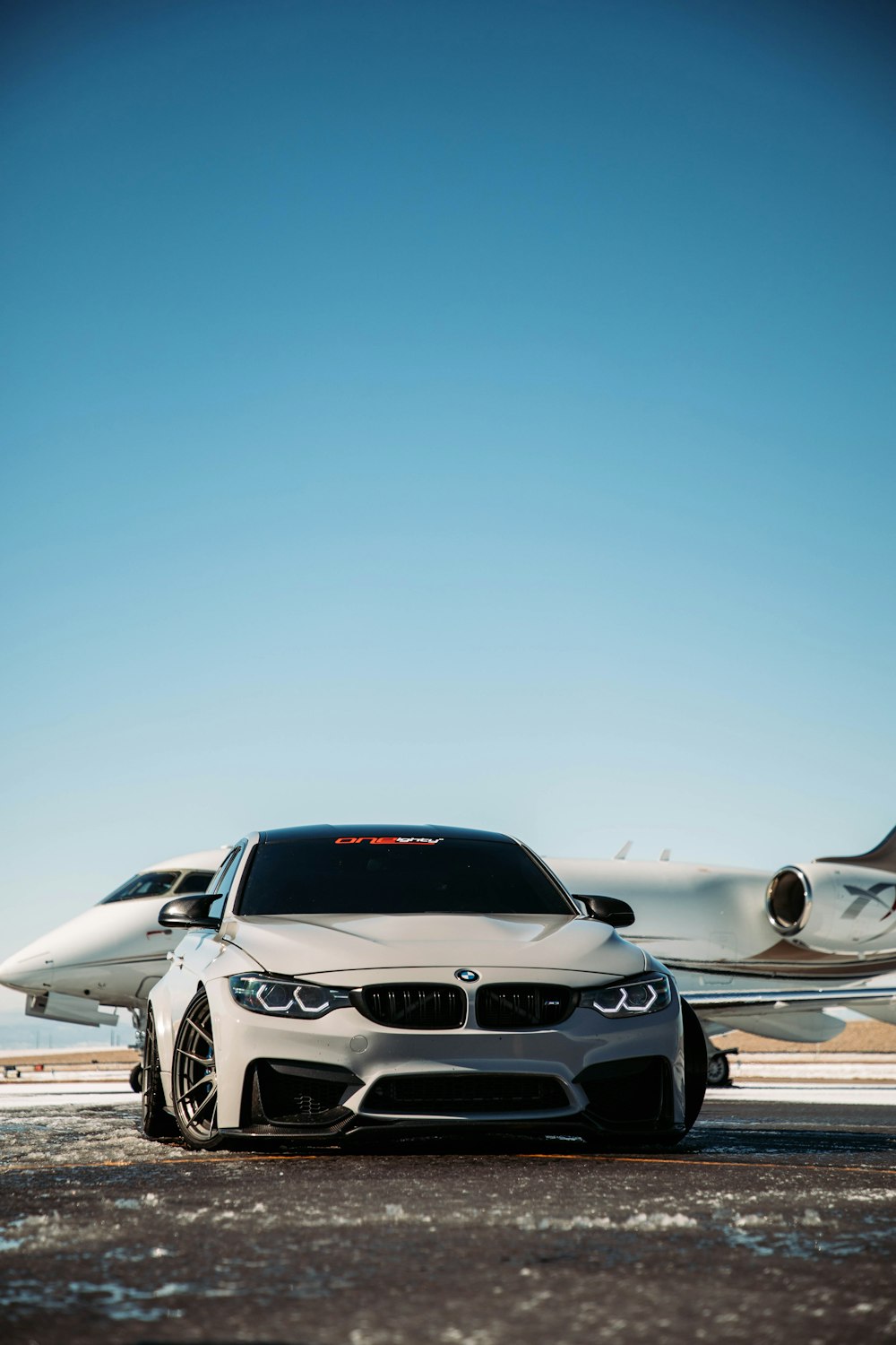 a white car parked in front of an airplane