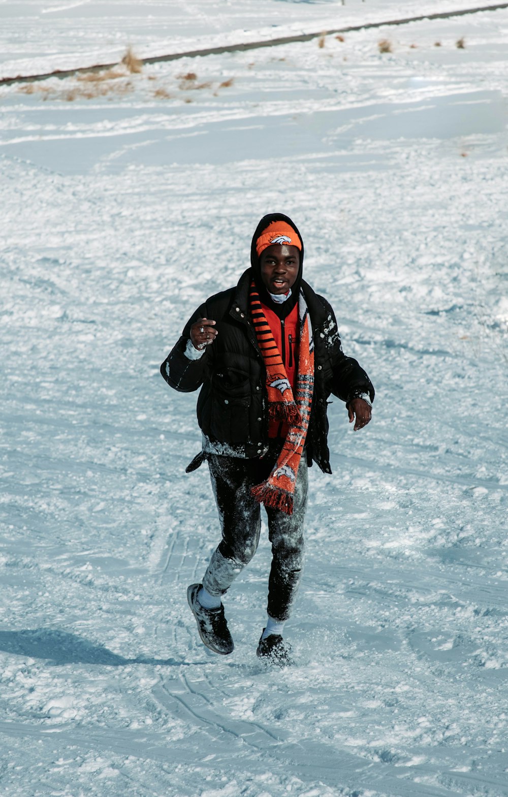 a man is running through the snow on a sunny day