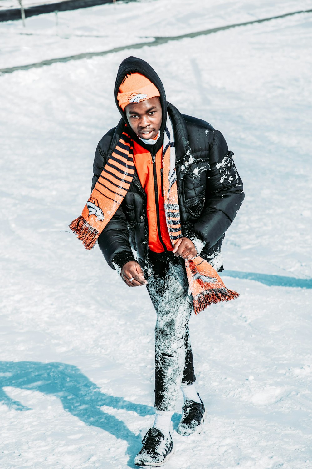 a man standing in the snow with a scarf around his neck