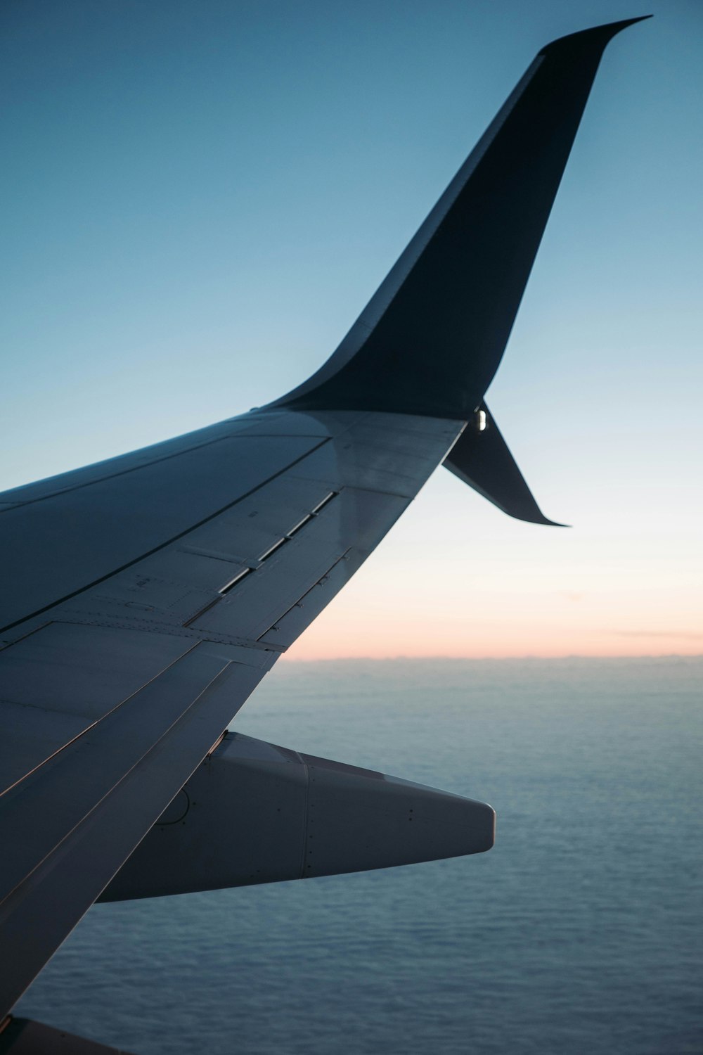 the wing of an airplane flying over the ocean