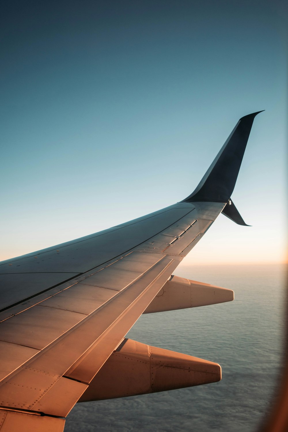 the wing of an airplane flying over the ocean