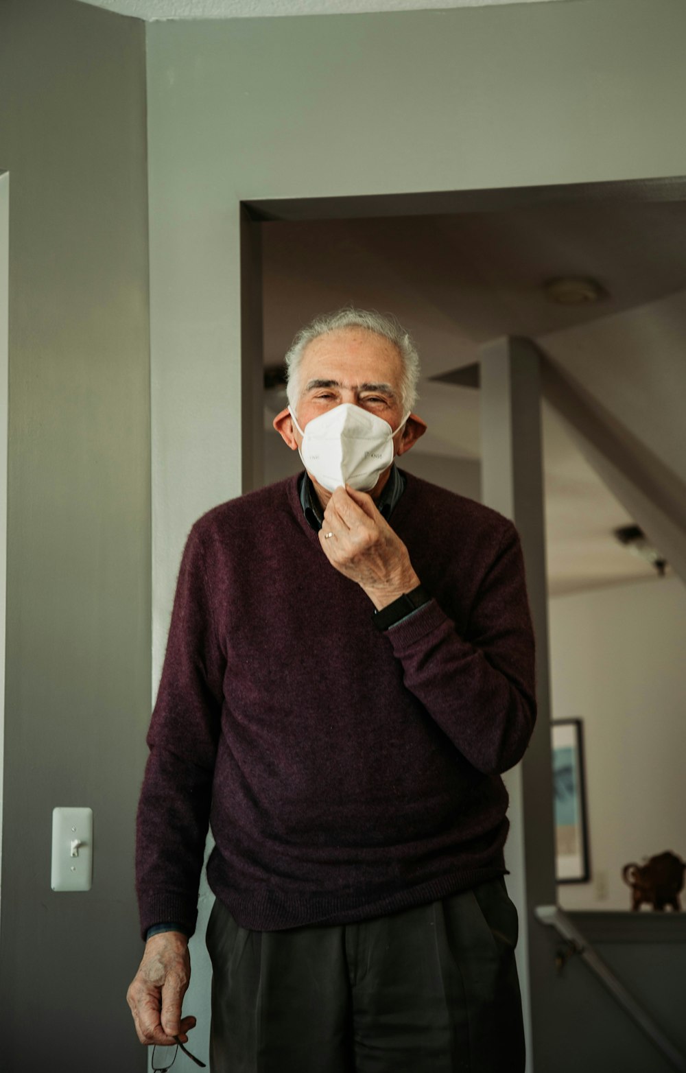 a man in a sweater is holding a napkin to his mouth