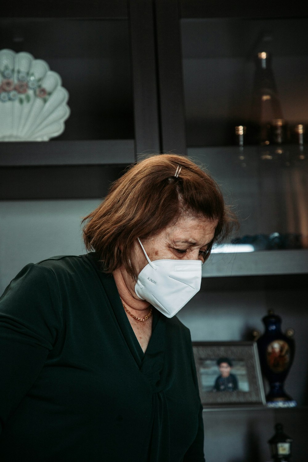 a woman wearing a face mask in a kitchen