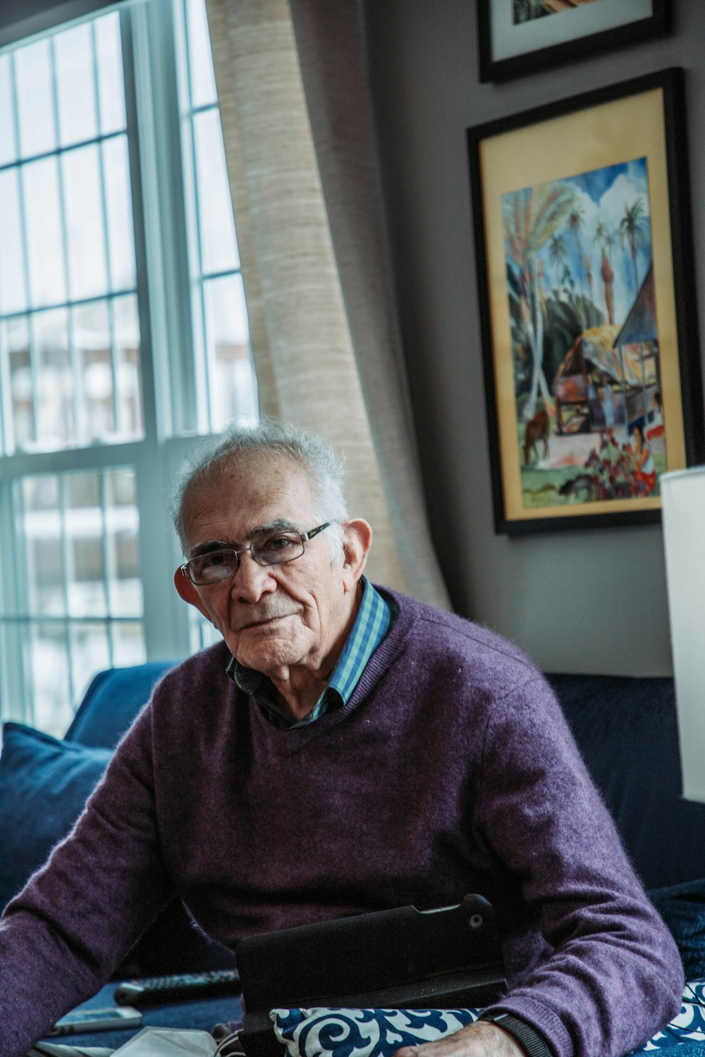 a man sitting on a bed with a tablet