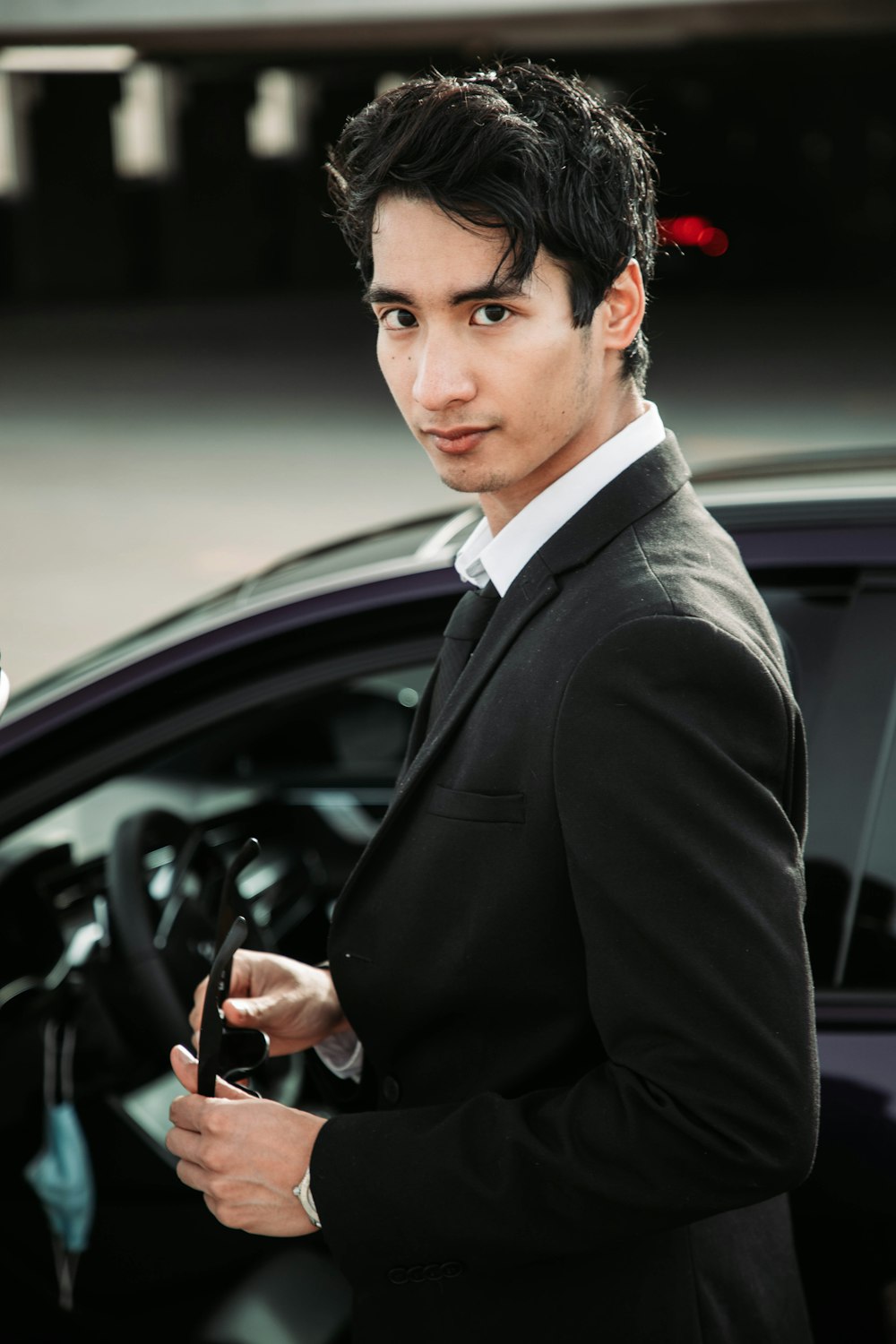 a man in a suit holding a car key