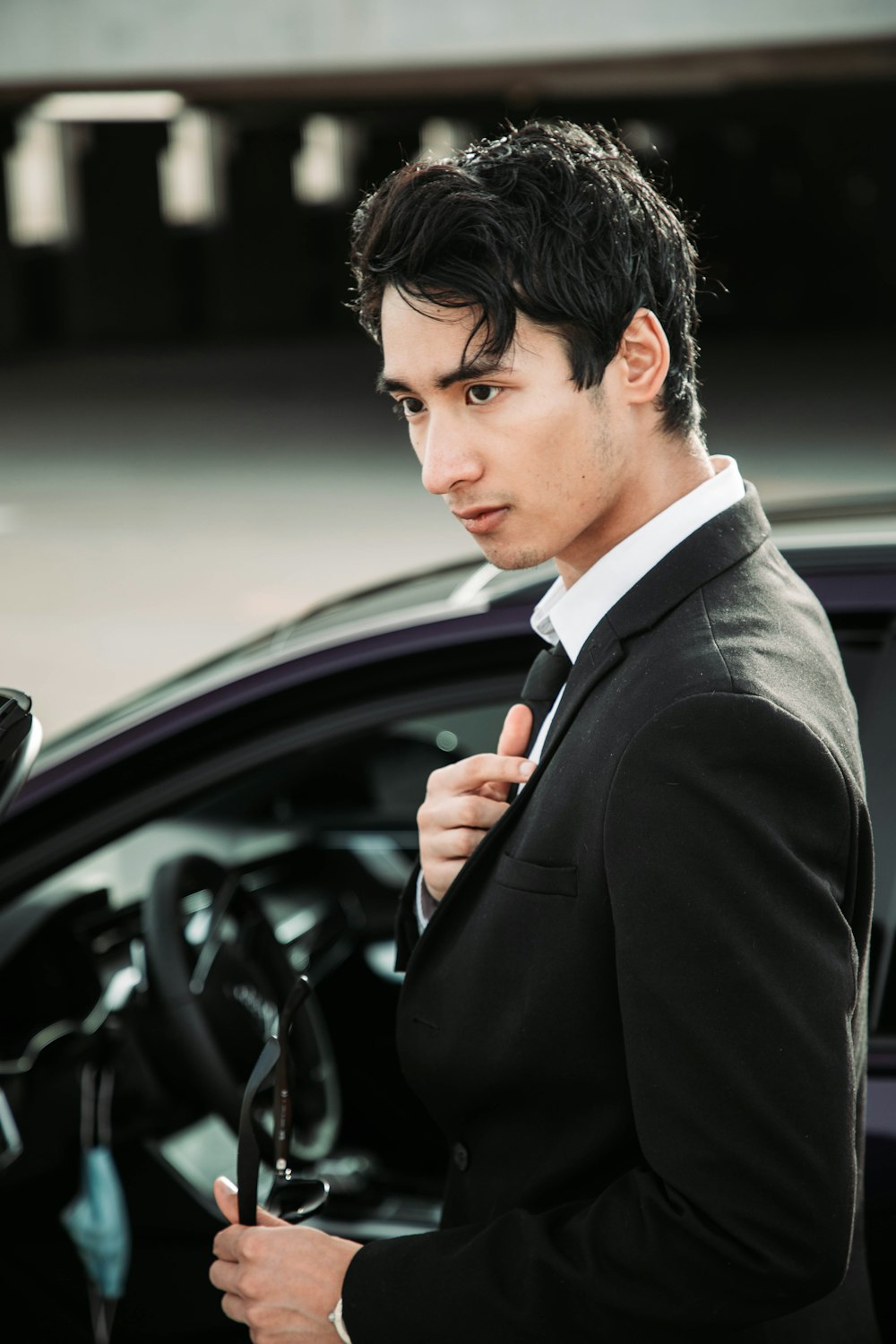 a man in a suit holding a steering wheel