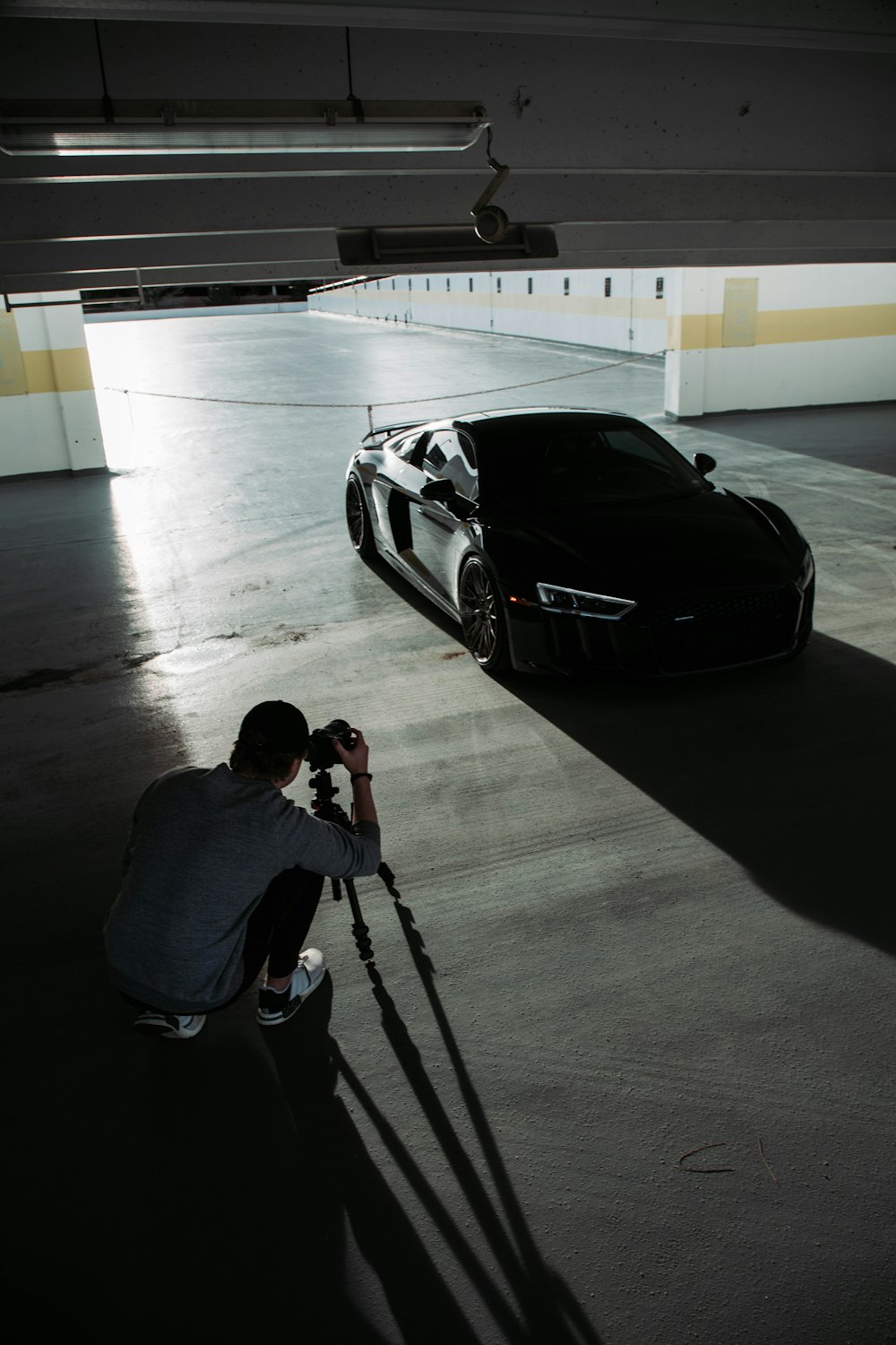 Un homme prenant une photo d’une voiture dans un garage