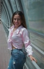 a woman is posing for a picture on a bridge