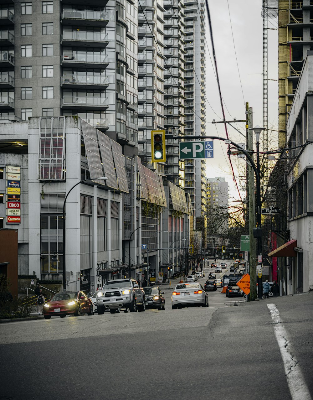 a city street filled with lots of traffic next to tall buildings