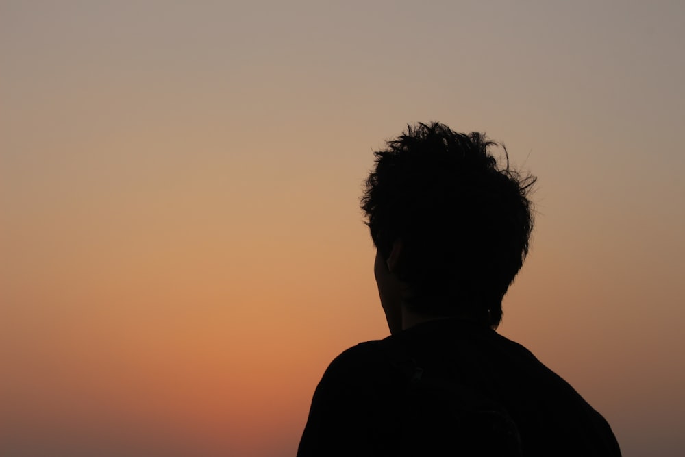 a person standing in front of a sunset