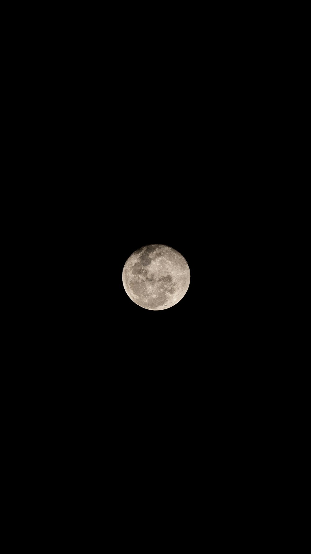 a full moon is seen in the dark sky